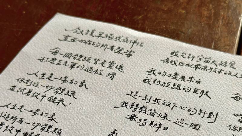 牌卡祝福語的手寫原稿，一字一句寫在紙上